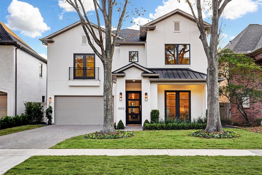 A white house with black windows and a driveway.