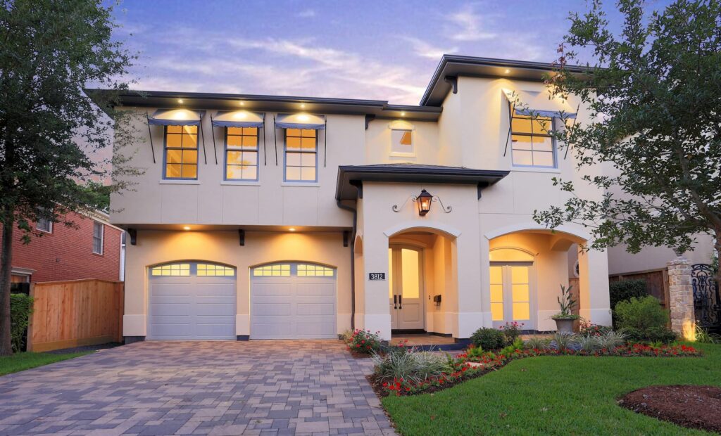 A large white house with two garage doors.